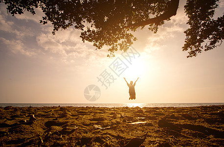 日落时 一个亚洲女孩在海滩上跳跃 日出 自然图片