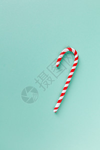 柔和的绿松石背景上的圣诞薄荷糖手杖 节日简约风格平躺 带有贺卡 邀请函 社交媒体复制空间的模型 垂直的图片