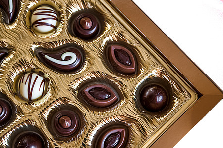 金盒中不同形状的巧克力糖果孤立于白色背景 关闭 食物图片
