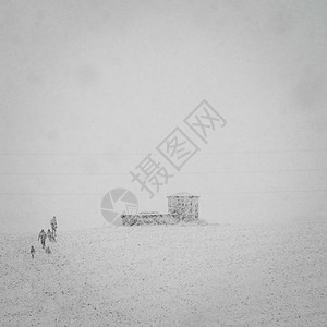 4人在大雪下爬上山丘图片