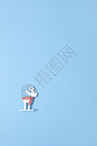 圣诞装饰品 玩具白鹿 在带复制空间的面纸蓝背景上围巾 节日 新年概念 垂直 平坦 最小样式图片