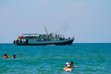 船上有海滨背景的渡假者船高清图片