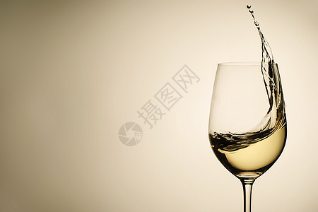 杯中白葡萄酒的悬浮滴水和喷洒图片