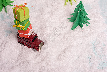 玩具车在雪上圣诞树下携带礼物 vie 鞠躬图片