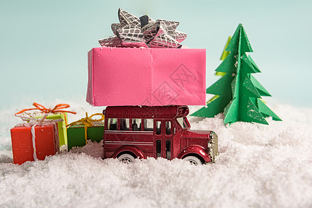 玩具车在雪上圣诞树下携带礼物 vie 纸图片