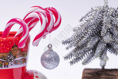 圣诞糖果甘蔗 在圣诞树后座的红杯里 新年的概念  圣诞之谷  咖啡 奶制品图片