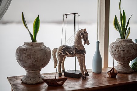 装饰性木马站在靠近窗户的桌子上 花盆里放着花 白瓶 铁船 房间装饰元素 装饰 普罗旺斯 精致的色调 剪裁 艺术图片