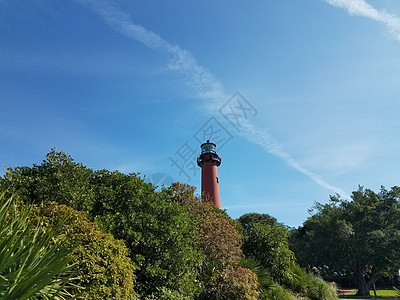 佛罗里达高高的红灯塔 配有树木和节日装饰品 旗帜 天空背景图片