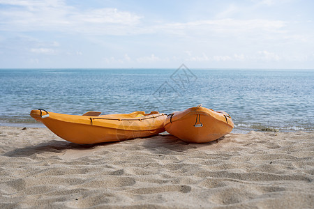 沙滩上的两艘彩色橙色皮划艇在阳光明媚的日子里为桨手做好准备 在沙子的几艘橙色消遣小船 活跃的旅游和水上娱乐 天空 运动图片