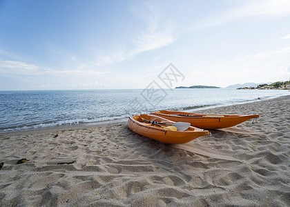 沙滩上的两艘彩色橙色皮划艇在阳光明媚的日子里为桨手做好准备 在沙子的几艘橙色消遣小船 活跃的旅游和水上娱乐 运输 假期图片