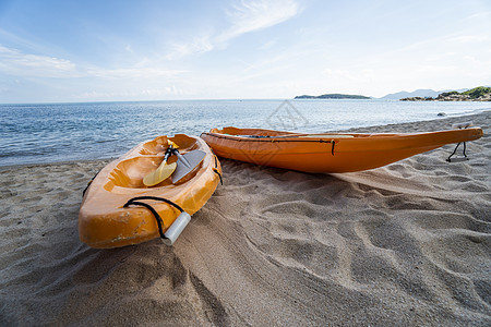 沙滩上的两艘彩色橙色皮划艇在阳光明媚的日子里为桨手做好准备 在沙子的几艘橙色消遣小船 活跃的旅游和水上娱乐 旅行 海图片