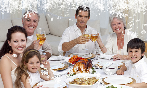 家庭在晚餐中喝着葡萄酒 对着镜头微笑的喜悦图片