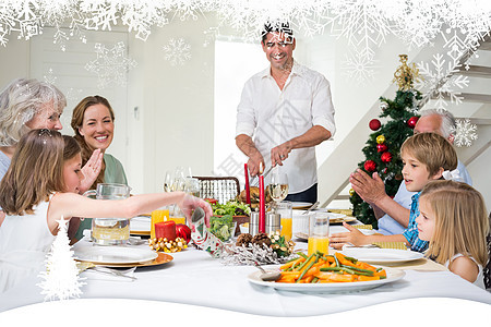 家庭在餐桌上享受圣诞节饭食的复合形象 女士图片