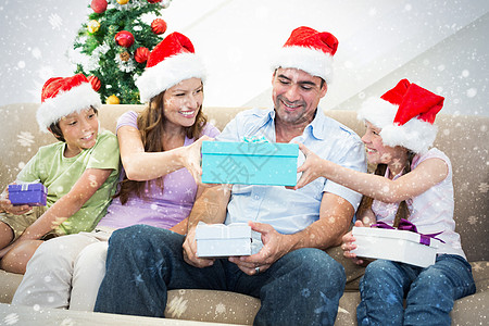 家庭交换圣诞礼物的复合形象;在圣诞节礼礼 雪 假期图片