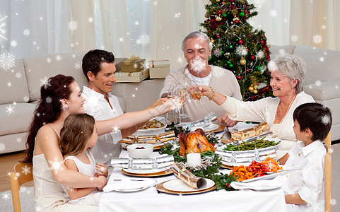 圣诞节晚宴上全家敬酒的复合形象图片