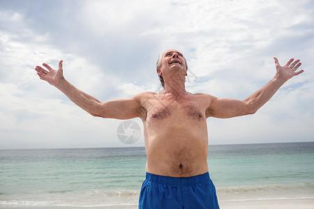 快乐的高级男子站在沙滩上 双臂伸展 幸福的 游客图片