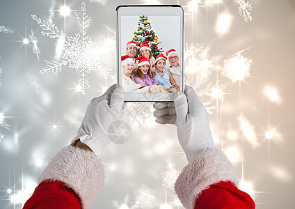 Santa Claus拿着带有圣诞节家庭照片的数字片片段 庆祝 客厅图片