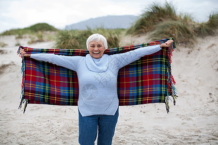 身手伸展的老女人站在沙滩上 海岸 海岸线 伸出双臂 指导图片