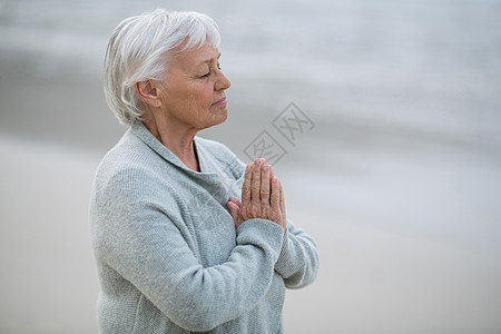 高级女子在沙滩上祷告 粘接 感情 双手合十 自由 娱乐图片