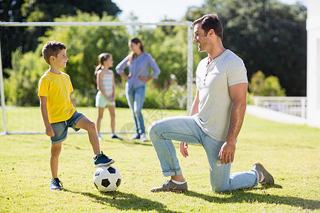 父亲和儿子在公园踢足球图片