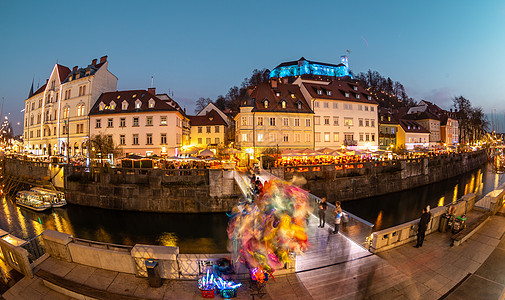 古城中心的Ljubljanica河岸景象充满活力 市中心在黄昏时装饰着圣诞灯 旧中世纪的Ljubljana山丘笼罩了城市 斯洛文图片