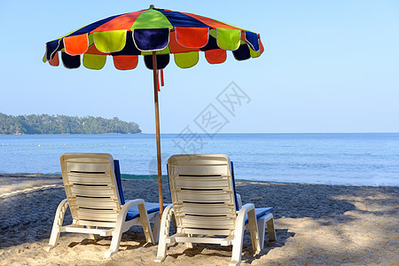 热带沙滩上带B的海滩床和喜悦多彩的阳伞图片