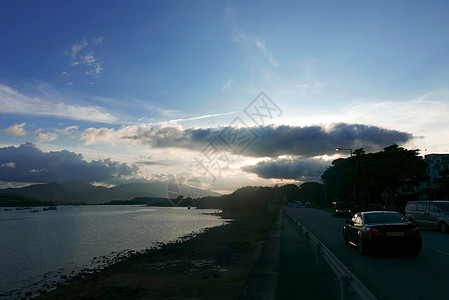 海洋 戏剧性的天空和路上的汽车 山 岛图片