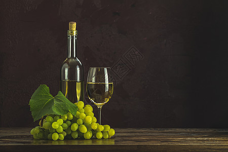 白葡萄酒和葡萄的玻璃杯和瓶子图片