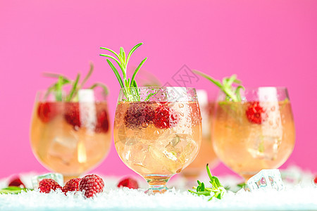 新鲜的草莓鸡尾酒 含迷迭香和玻璃杯中的冰 蓝色的 酒精图片