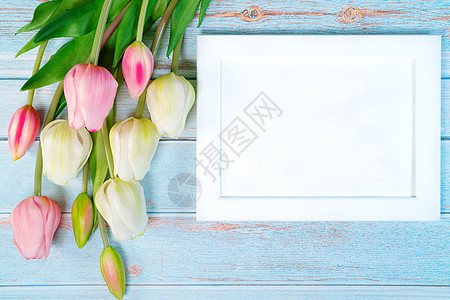 白色图片框和木制桌背景上的花朵图片
