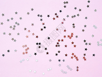 假日背景与粉红色背景上的银色星星五彩纸屑 圣诞节和新年贺卡的好背景 平面布局视图 平躺 魔法背景图片
