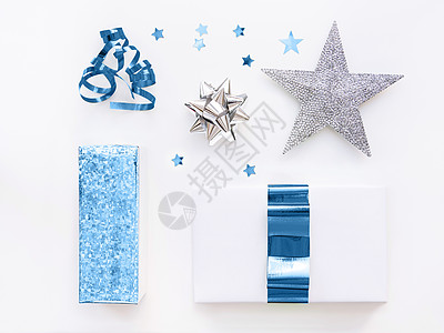 彩色银纸包裹的礼物 上面有经典的蓝丝带和蝴蝶结 星形面板和白色的复制空间图片