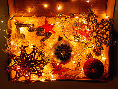 装有圣诞和新年装饰品及灯光的纸板盒 黑暗的 箱背景图片