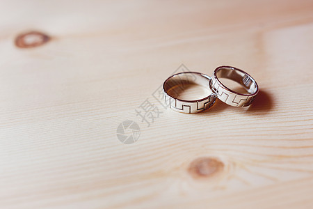 双金色结婚戒指与木制背景上的几何装饰 爱情婚姻的象征和第五个木制结婚纪念日图片