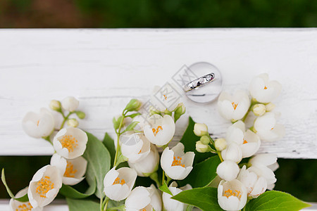 带有钻石的金色结婚戒指位于新娘花束中的茉莉花 花内 爱情和婚姻的象征 婚礼花束 新娘的传统象征性配饰 与茉莉花的花卉组成 浪漫的图片