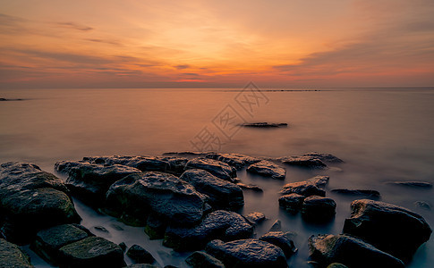 日落时在石滩上的岩石 美丽的海滩夕阳天空 热带 天际线图片