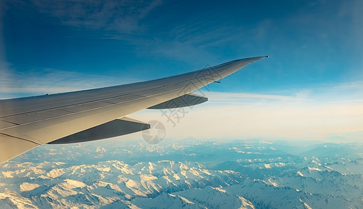 用白雪飞越山顶上空的飞机翼 飞机飞翔 商业图片