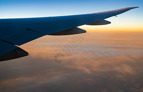 飞机在白云上空飞翔 日出时空飞行图片