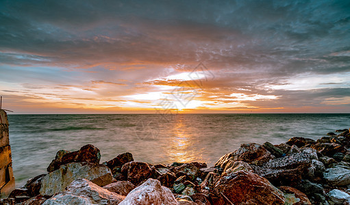 日落时在石滩上的岩石 美丽的海滩夕阳天空 戏剧性 热带图片