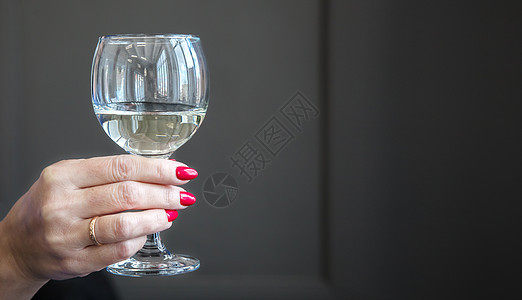 女性手握着一杯白葡萄酒的玻璃杯图片