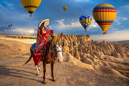 土耳其卡帕多西亚的旅游者享受骑马和寻找气球图片
