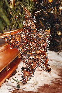圣诞和新年背景与冷杉树和明亮的装饰星-户外装饰由柳树枝制成 带有灯泡花环 雪 户外的图片