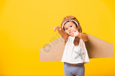 小男孩笑笑 戴着飞行员帽子玩耍 带着玩具卡的护目镜 女孩 美丽的图片