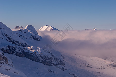 山峰黄昏日落时的黄昏阿尔卑斯山 冬天 新雪 连续下坡 滑雪缆车 岩石背景