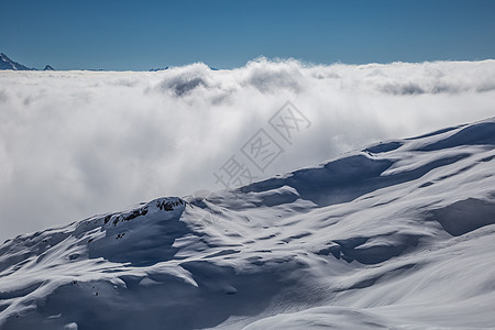 山岳的全景 从云中升起 娱乐 危险 滑雪板 滑雪缆车 连续下坡图片