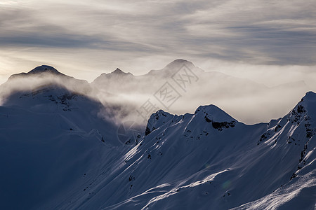 日落前从云中升起的山峰 冬季运动 山脉 寒冷的 蓝色的 冬天图片