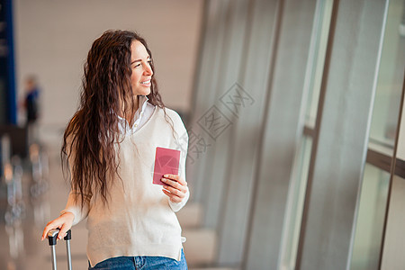 在国际机场提着行李的年轻女子 航空公司乘客在机场休息室等待飞行飞机 假期 女孩图片