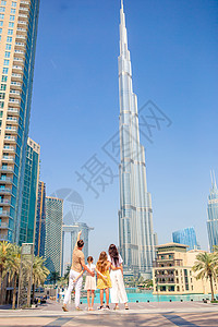 一家人快乐地在迪拜走来走去 背景中还有摩天大楼 地标 建筑学图片