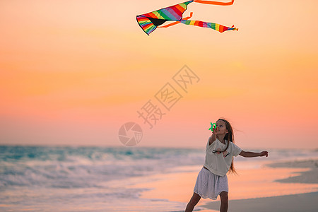 小姑娘在海滩上放风筝 喝松松水 热带 海岸 海岸线图片