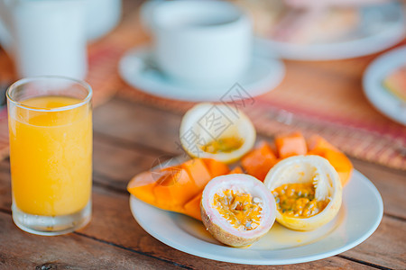 美味的异国水果 - 成熟的激情水果 芒果 在户外休息室吃早餐 绿松石 提神图片